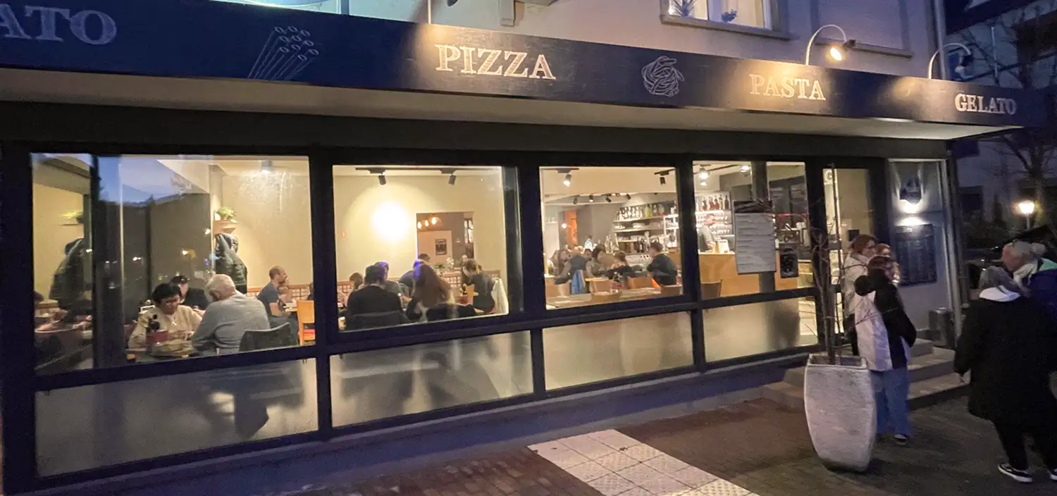 Ristorante Pomodorino Marktheidenfeld, Außenbereich, beleuchtete Fensterfront mit Blick in den Gastraum